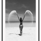 Sexy lady woman throwing sand on a beach in black and white, coastal ocean. 