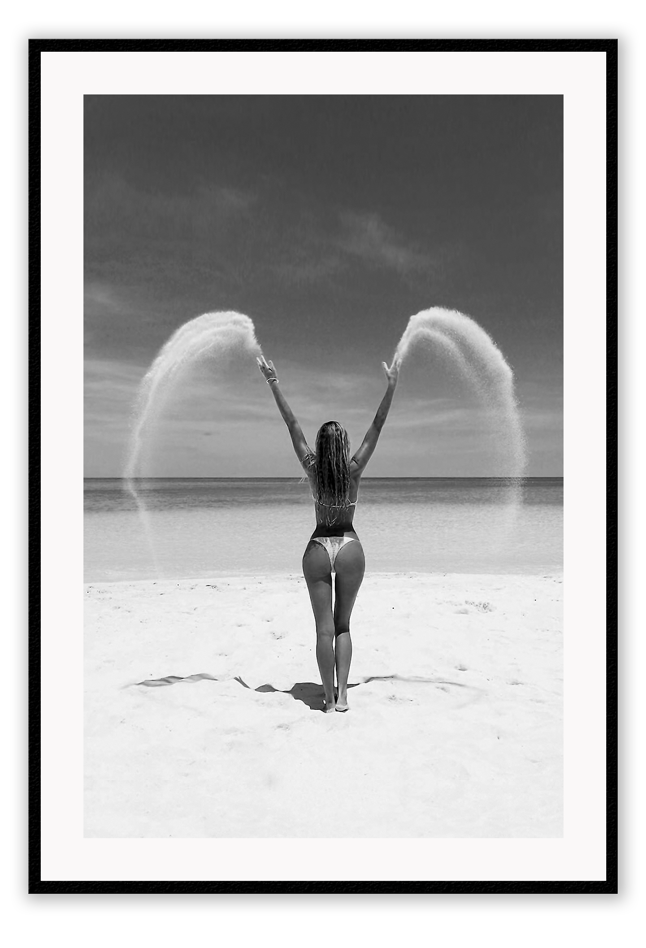 Sexy lady woman throwing sand on a beach in black and white, coastal ocean. 