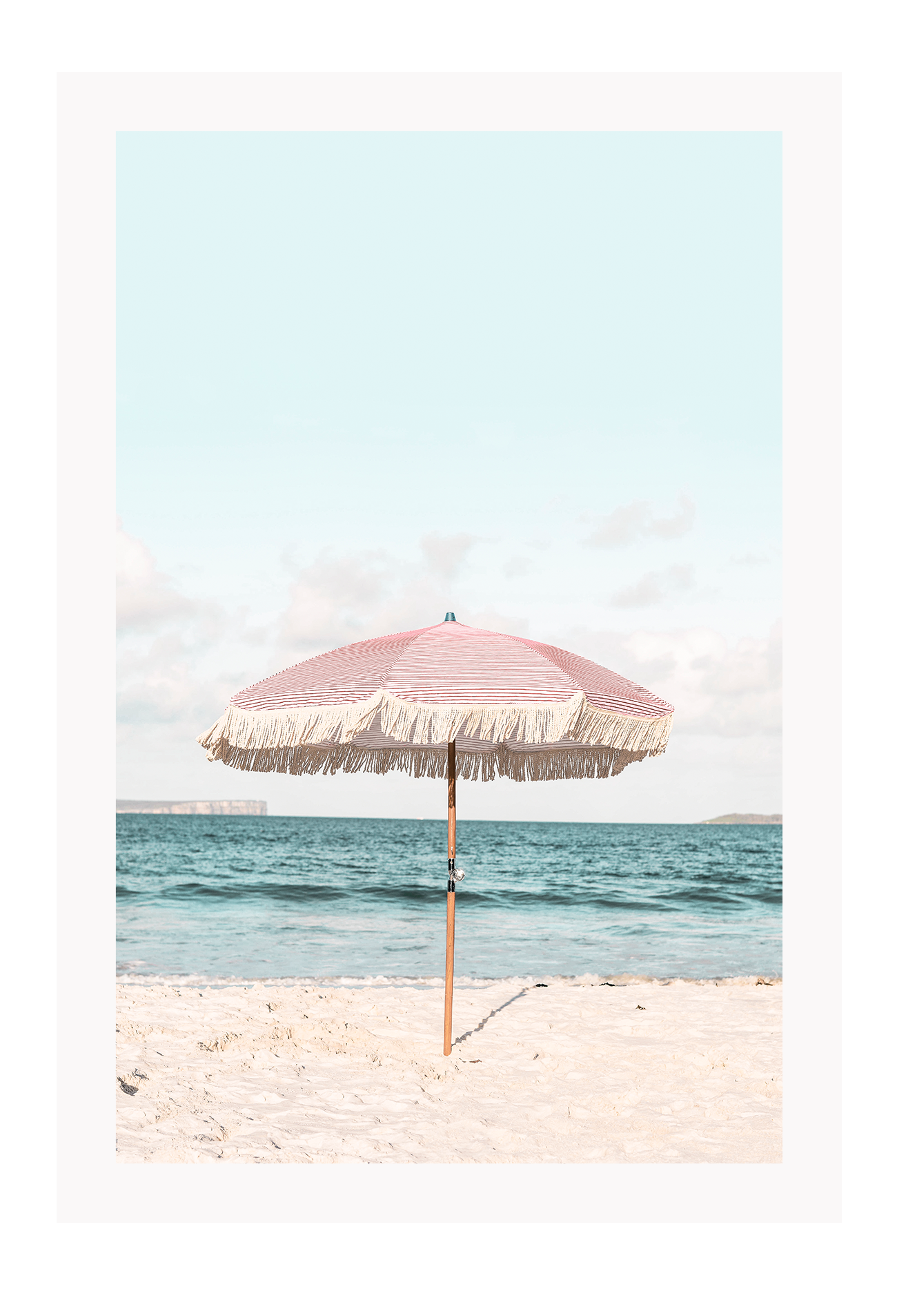 A natural wall art with a pink umbrella on the summer beach in Bali pastel tones and boho style