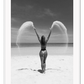 Sexy lady woman throwing sand on a beach in black and white, coastal ocean. 