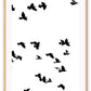 A black and white wall art with black sky birds in white sky. 